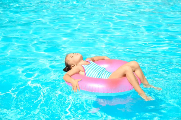 Liten flicka med rosa gummiring i poolen — Stockfoto