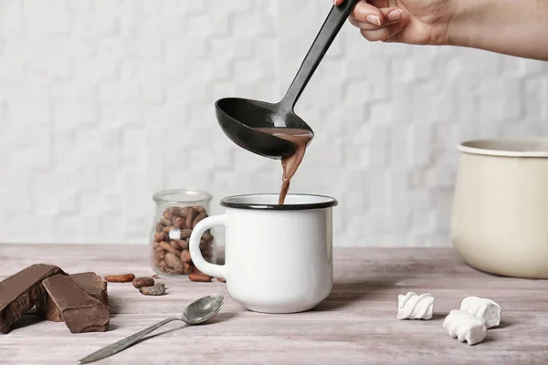 Pouring hot cocoa drink into cup — Stock Photo, Image