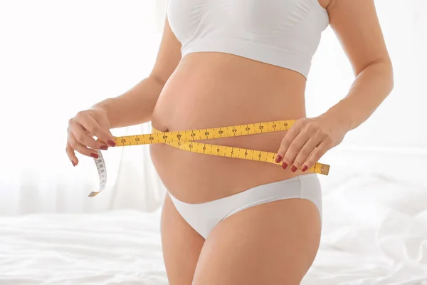 Mujer embarazada midiendo el vientre — Foto de Stock