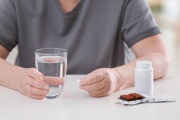 Woman with pills and glass of water — Stock Photo, Image