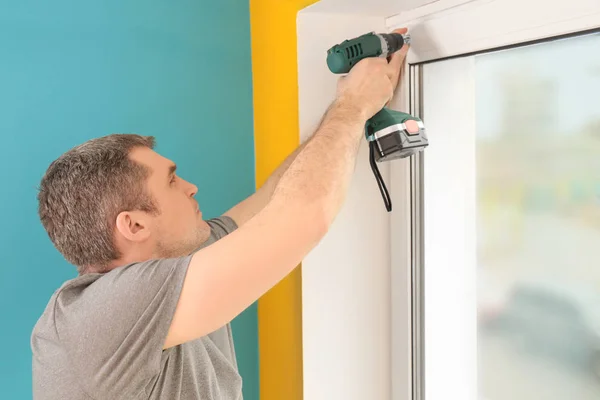 Young man installing window shades — Stock Photo, Image