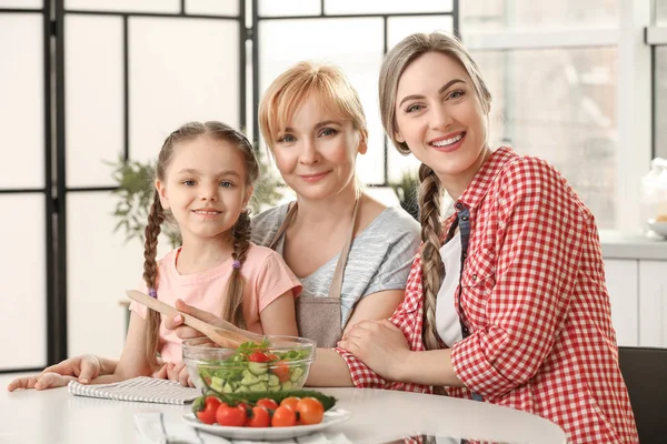 Jovem mulher com mãe e filha na cozinha — Fotografia de Stock