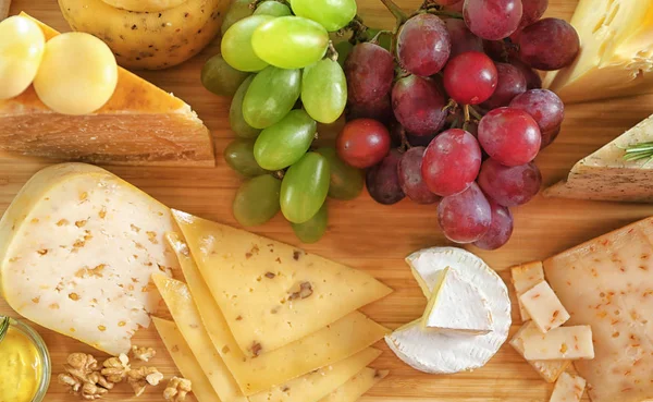 Different types of cheese with grapes — Stock Photo, Image