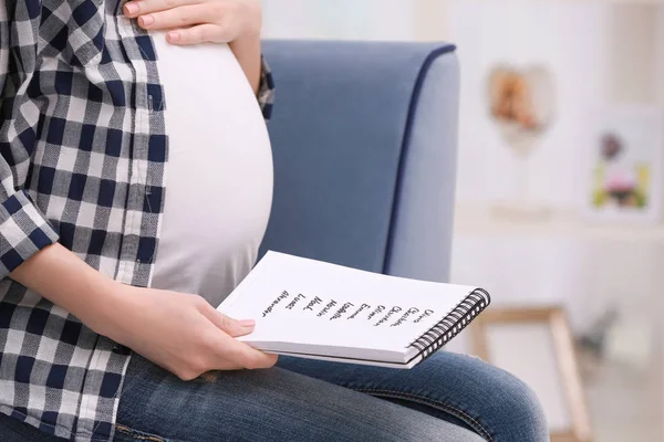 妊娠中の女性は赤ちゃんの名前のリストを保持 — ストック写真