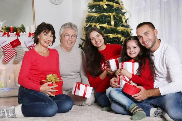 Ευτυχισμένη οικογένεια με τα Χριστούγεννα παρουσιάζει στο σαλόνι — Φωτογραφία Αρχείου