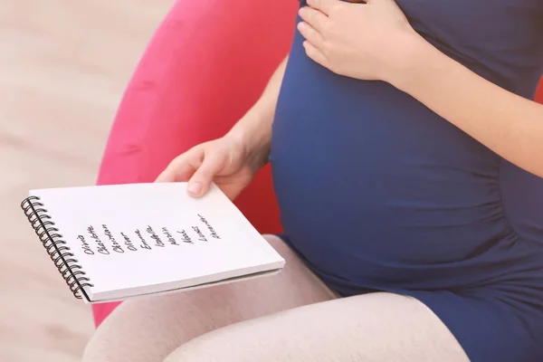 Mulher grávida segurando lista de nomes de bebês — Fotografia de Stock