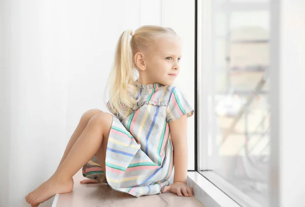 Chica sentada en alféizar de la ventana — Foto de Stock