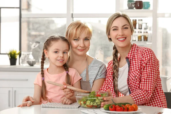 Wanita muda dengan ibu dan anak di dapur — Stok Foto