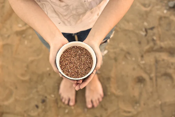 Poor woman holding buckwheat