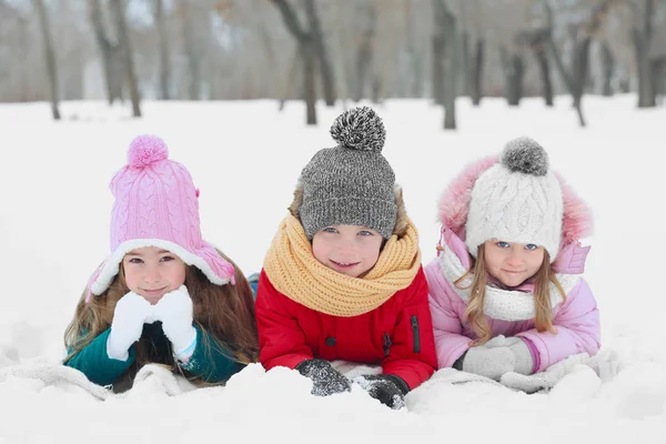 Szczęśliwe dzieci leżąc na śniegu — Zdjęcie stockowe
