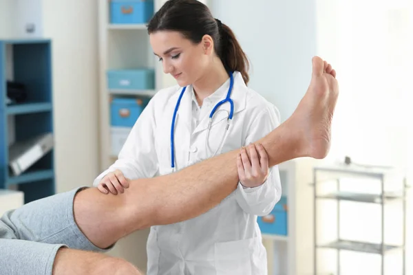 Ortopedista examinando paciente na clínica — Fotografia de Stock