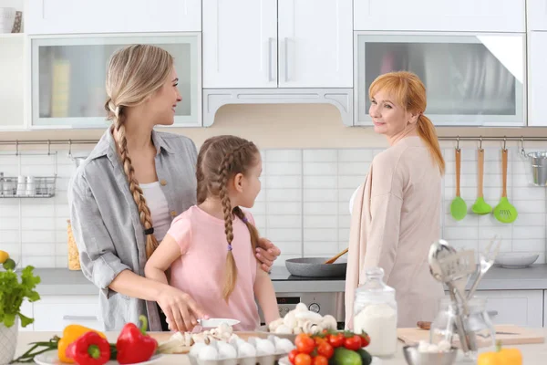 Wanita muda, putrinya dan ibunya memasak di dapur — Stok Foto