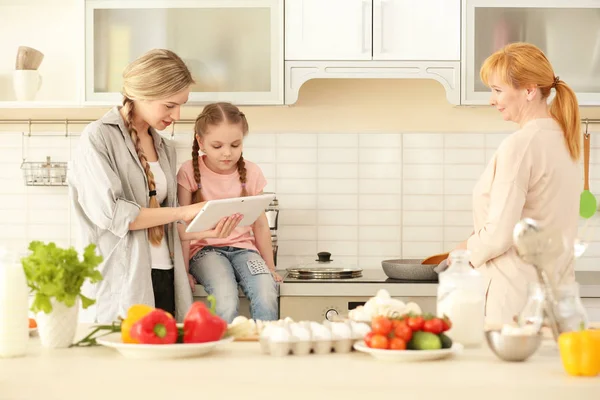 Молода жінка з дочкою і матір'ю на кухні — стокове фото