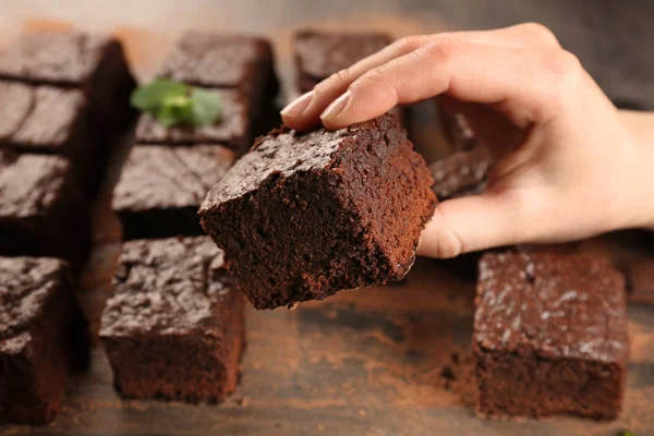 Woman holding piece of chocolate cake — Stock Photo, Image