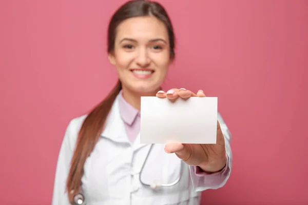 Beautiful young doctor with business card