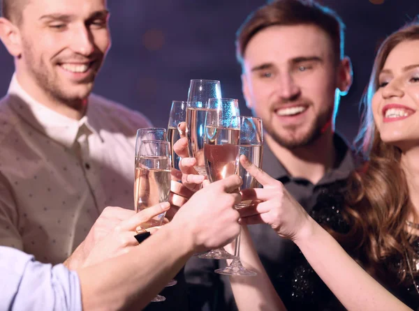 Friends clinking glasses of champagne at party in night club — Stock Photo, Image