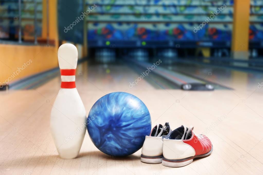 Ball, pin and shoes on floor