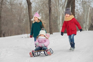Eğleniyor ve karda kızakla mutlu çocuk