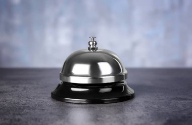 Gümüş servis bell karşı açık renkli ahşap masa üzerinde