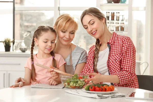 Jovem mulher com mãe e filha na cozinha — Fotografia de Stock