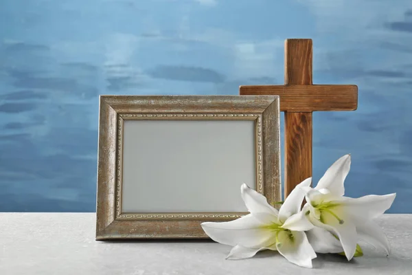 Cruz de madeira, lírio branco e quadro na mesa — Fotografia de Stock