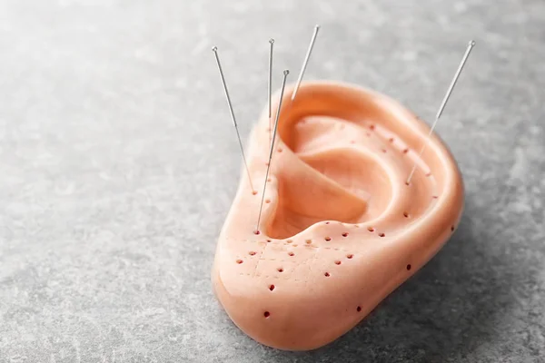 Nålar för akupunktur och mockup av mänskliga örat — Stockfoto
