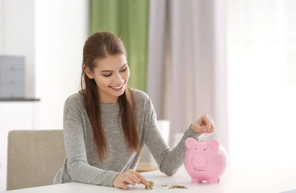 Bela Jovem Mulher Colocando Moedas Porquinho Banco Casa — Fotografia de Stock