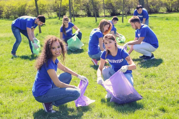 Група молодих добровольців, що збирають сміття в парку — стокове фото