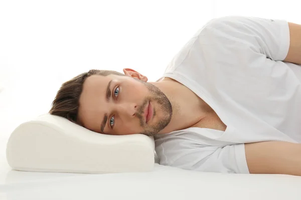 Молодой человек лежит на кровати — стоковое фото