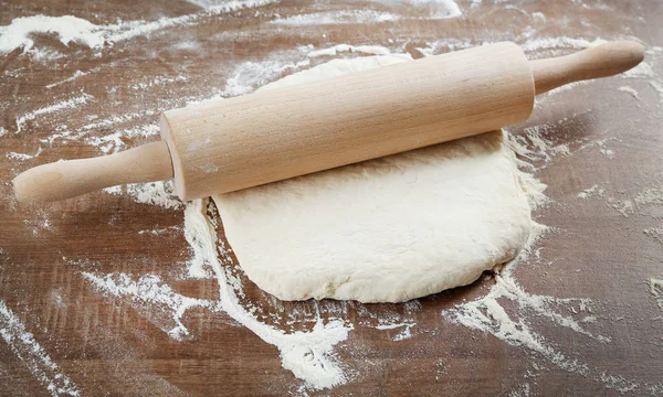 Raw dough and rolling pin — Stock Photo, Image