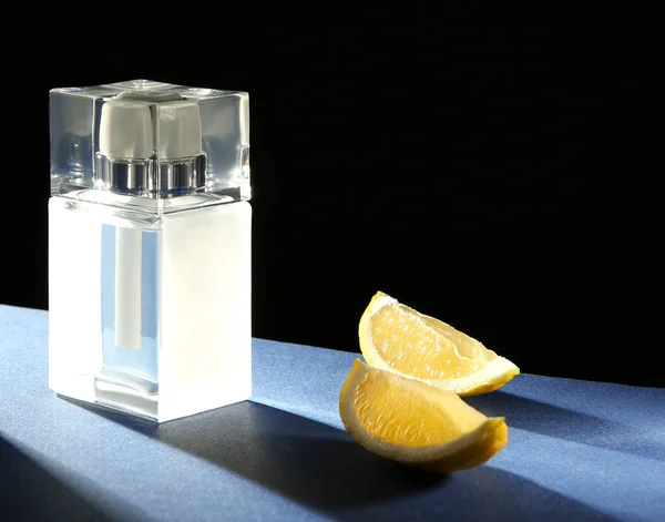 Bottle of modern male perfume and citrus slices on dark background — Stock Photo, Image