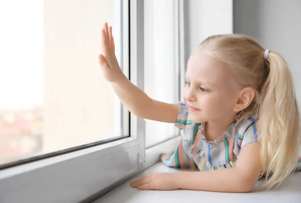 Girl sitting on windowsill — Stock Photo, Image