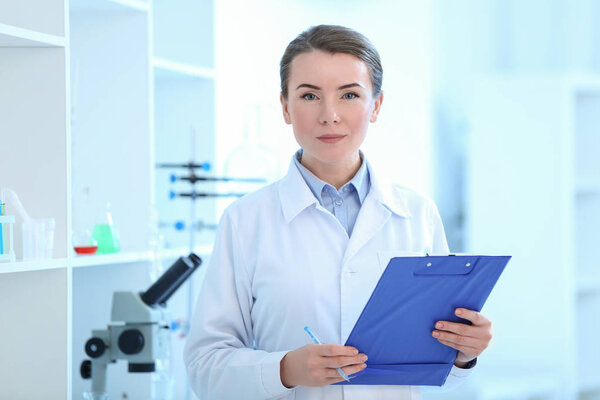 Scientist with clipboard in laboratory