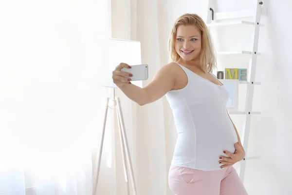 Mujer embarazada con teléfono inteligente — Foto de Stock