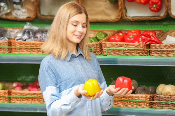 Schöne Frau kauft Gemüse — Stockfoto