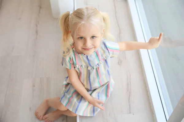 Girl sitting on windowsill — Stock Photo, Image