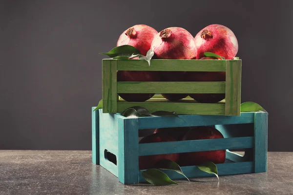 Dřevěné boxy s granátová jablka — Stock fotografie