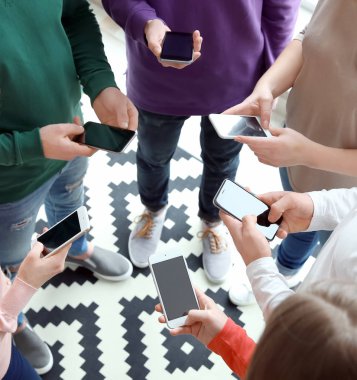 Daire içinde ayakta ve akıllı telefonlar kullanarak