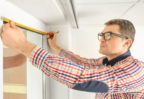 Hombre joven instalando persianas —  Fotos de Stock