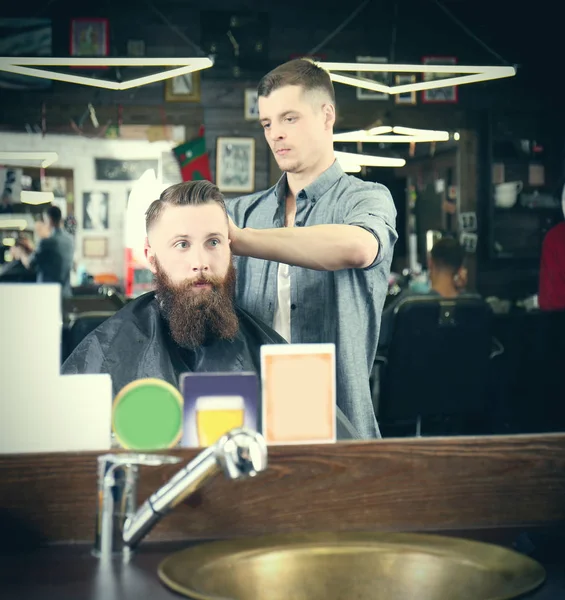 Cabeleireiro trabalhando com cliente na barbearia — Fotografia de Stock