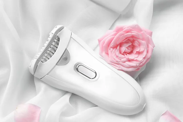 Modern epilator and flower — Stock Photo, Image