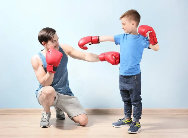 Отец и сын во время тренировки по боксу — стоковое фото