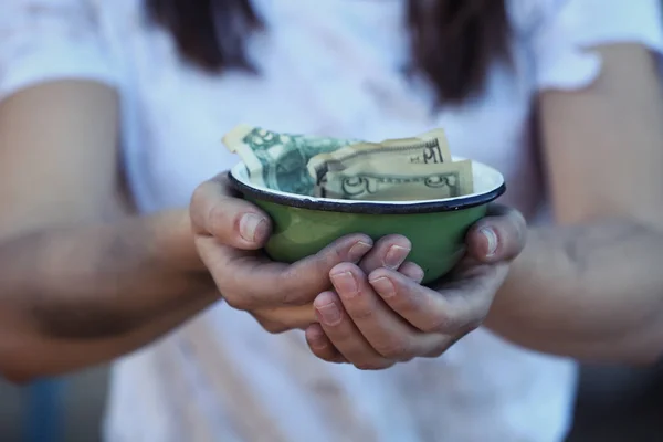 Woman holding bowl with money — Stock Photo, Image