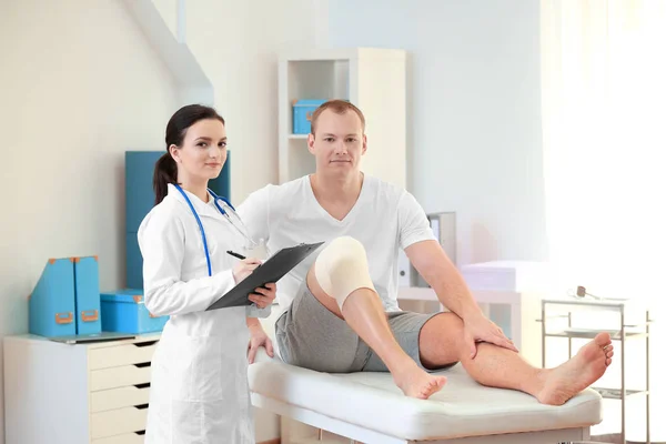 Orthopedist met patiënt in kliniek — Stockfoto