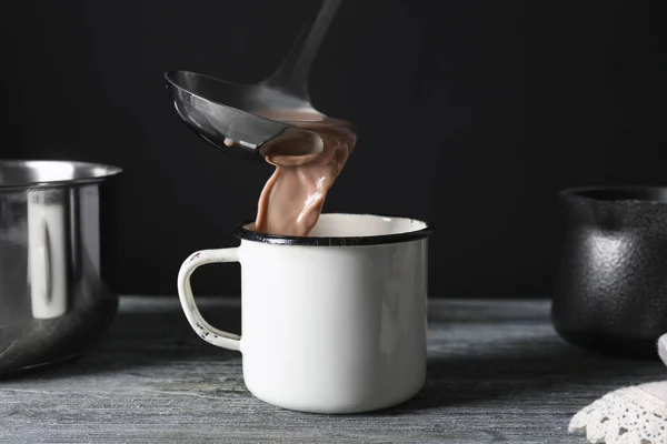 Pouring tasty cocoa into mug — Stock Photo, Image