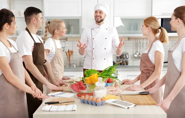 Chefe masculino e grupo de pessoas em aulas de culinária — Fotografia de Stock