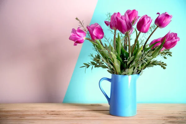 Jug with beautiful bouquet of spring flowers on wooden table — Stock Photo, Image