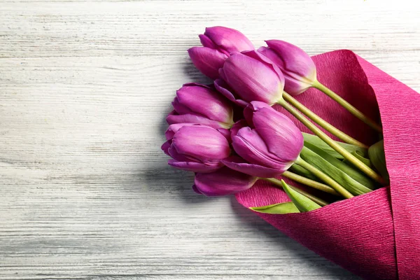 Bellissimo bouquet di tulipani lilla su sfondo di legno chiaro — Foto Stock