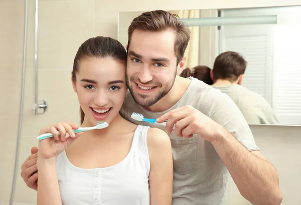 Pareja joven cepillándose los dientes — Foto de Stock