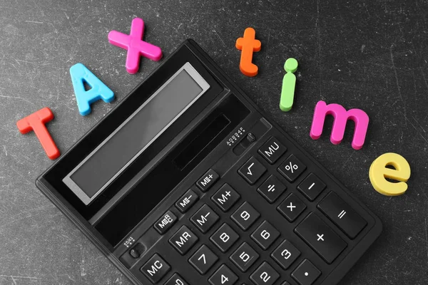 Letras coloridas TAX TEMPO e calculadora — Fotografia de Stock